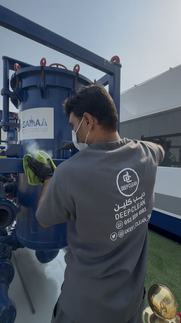 Deep Clean technician steam-cleaning industrial equipment